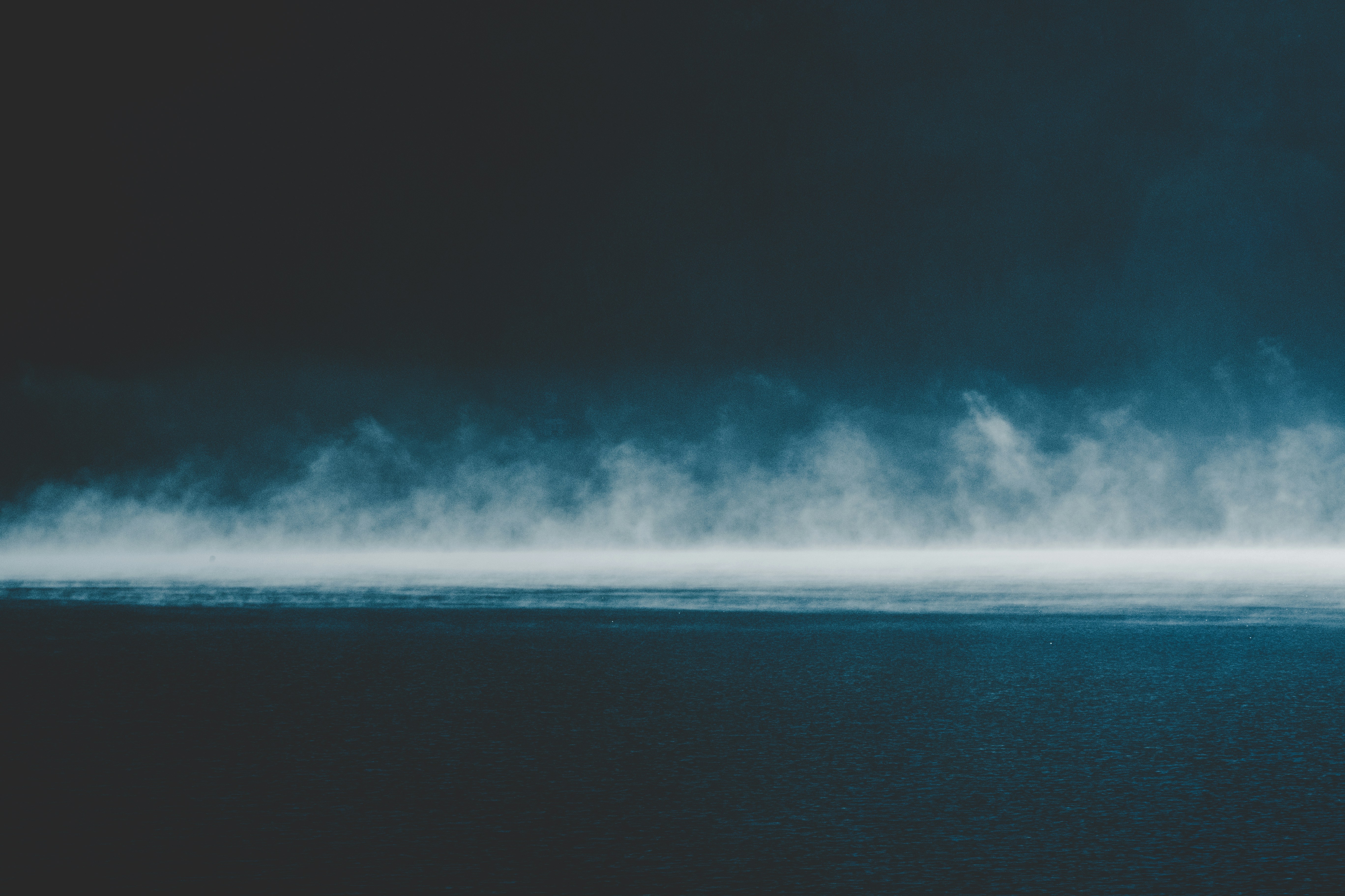 white fog rising above ocean