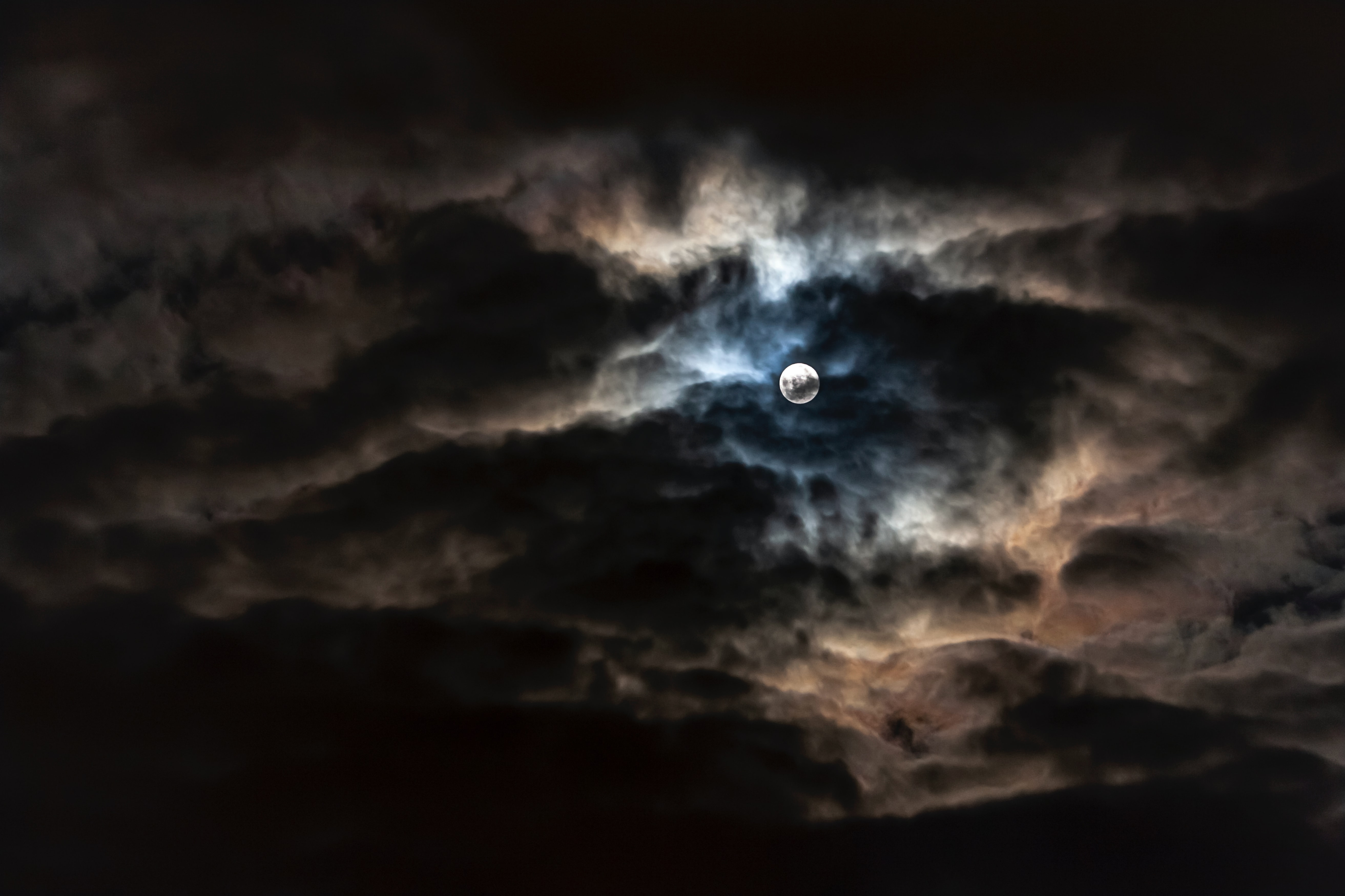 full moon breaking through dark clouds