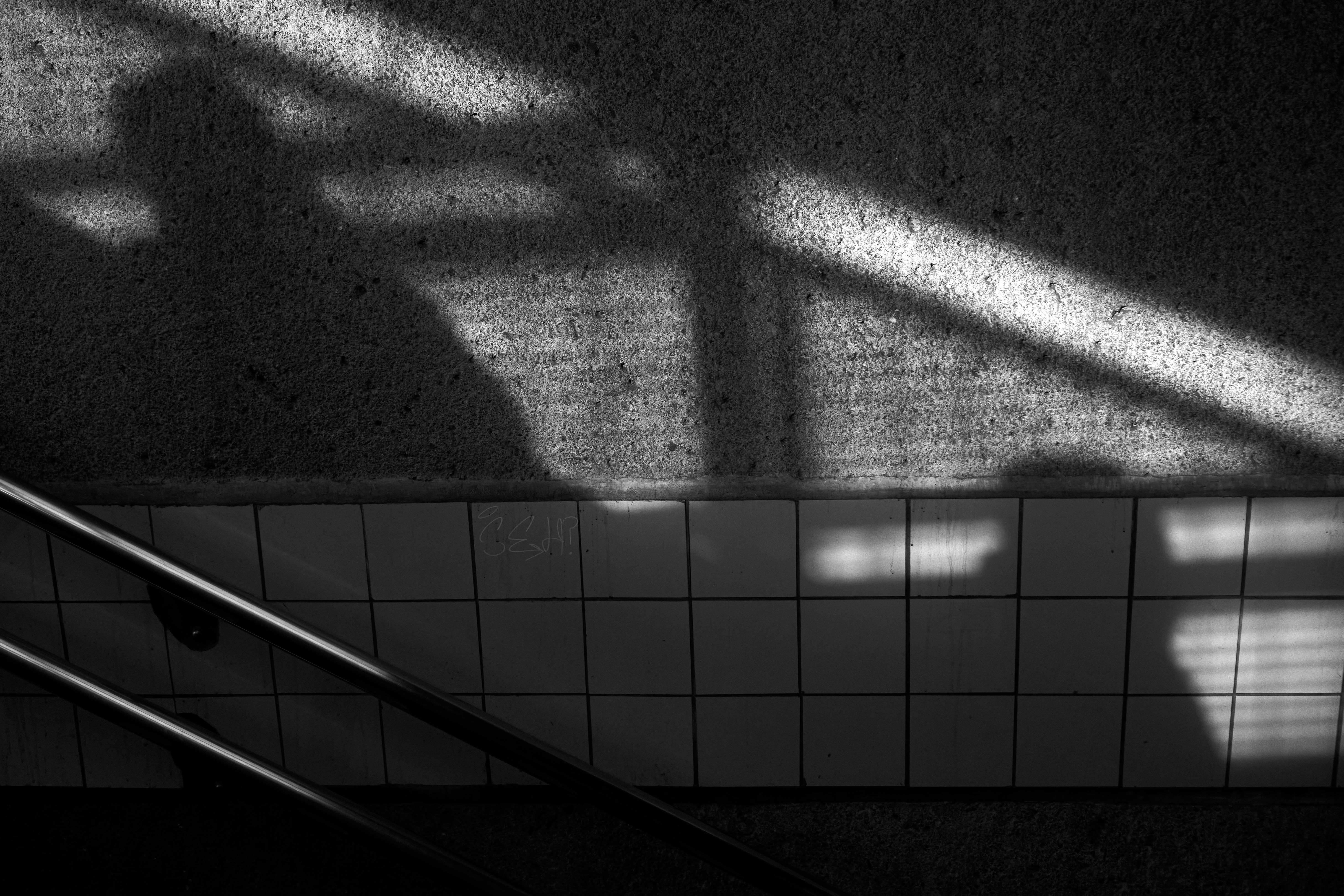 peoples shadows against wall in b&w