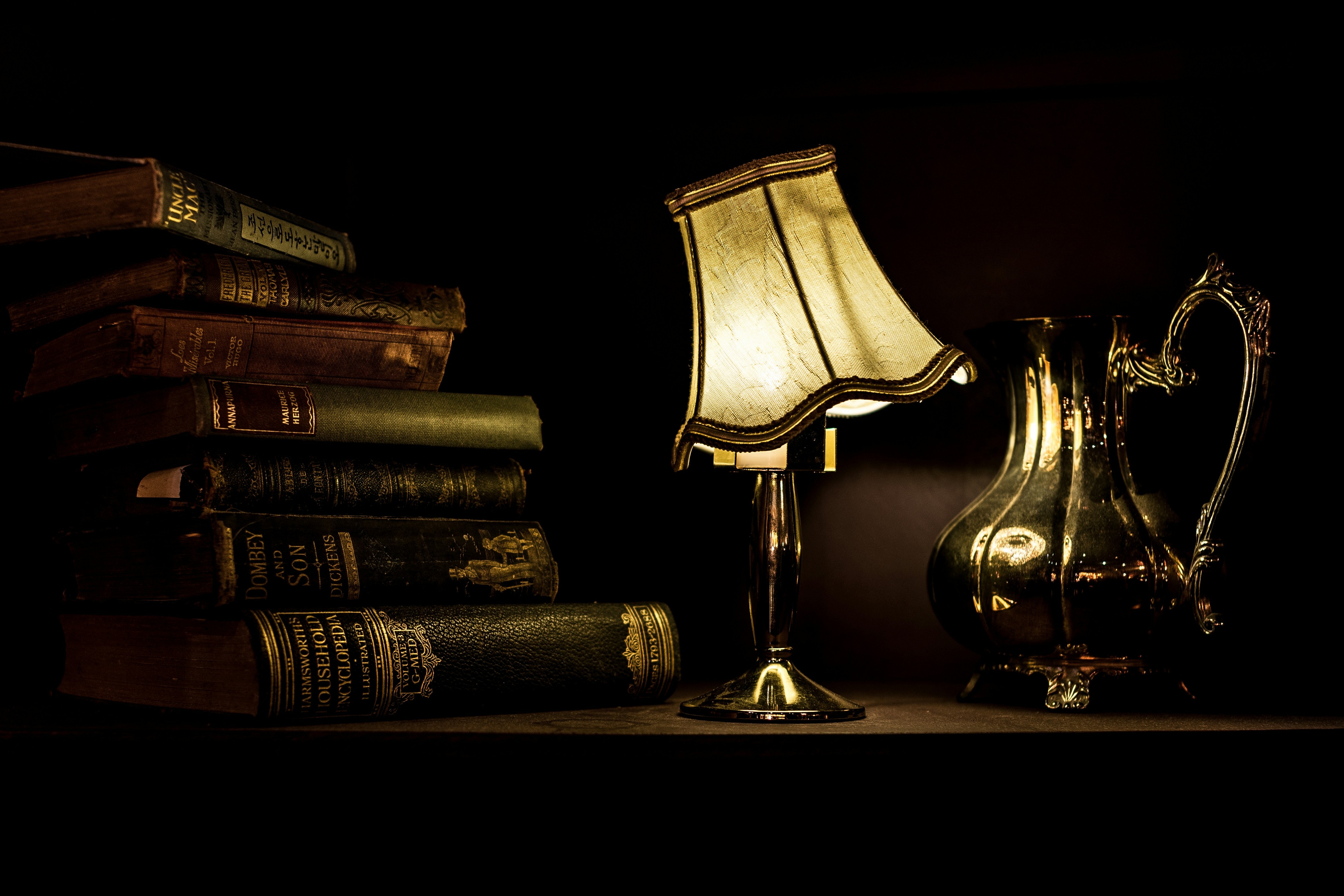 dark books with vintage lamp and metal pot