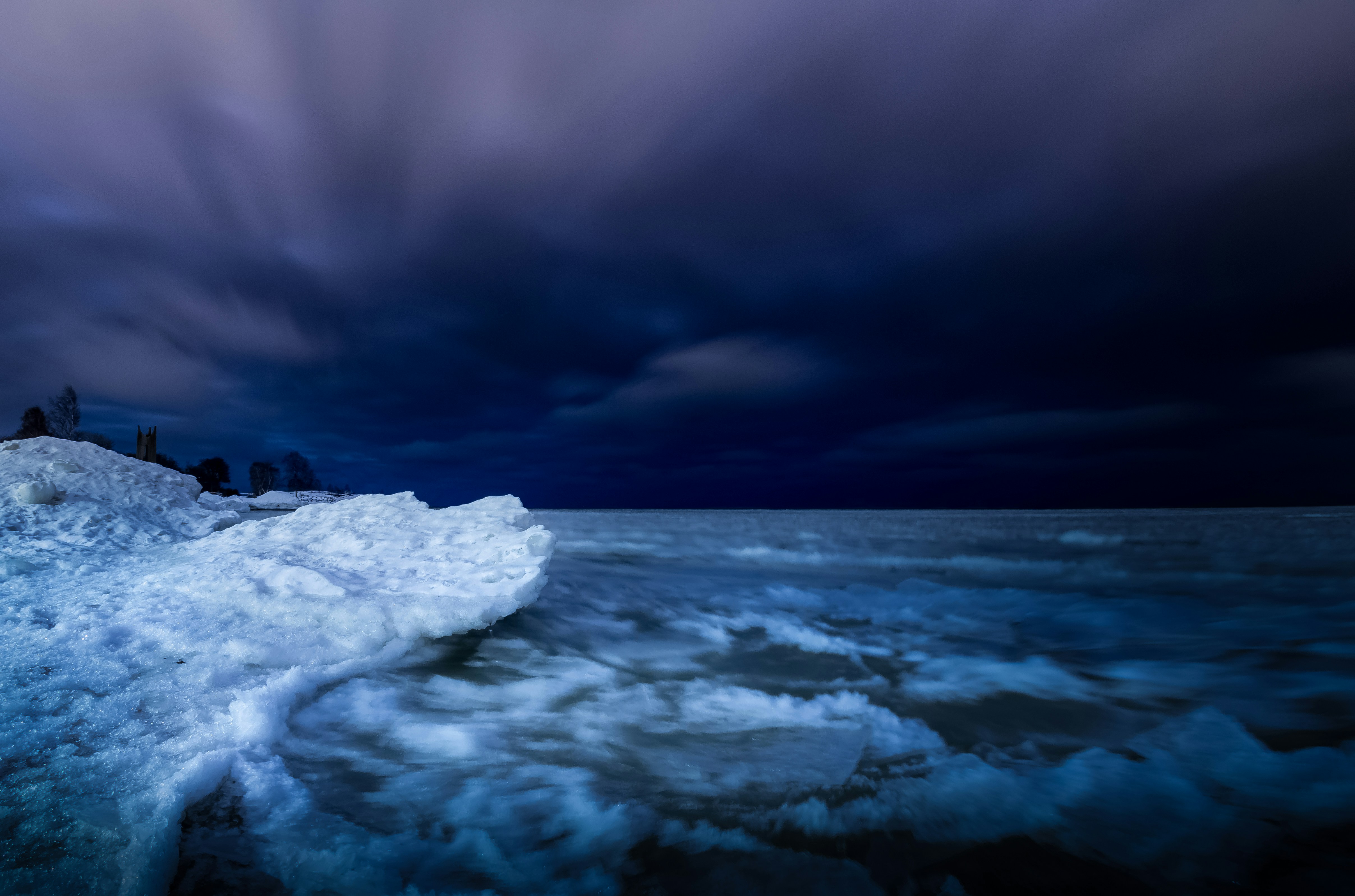 dark purple/blue waters broiling ashore at night