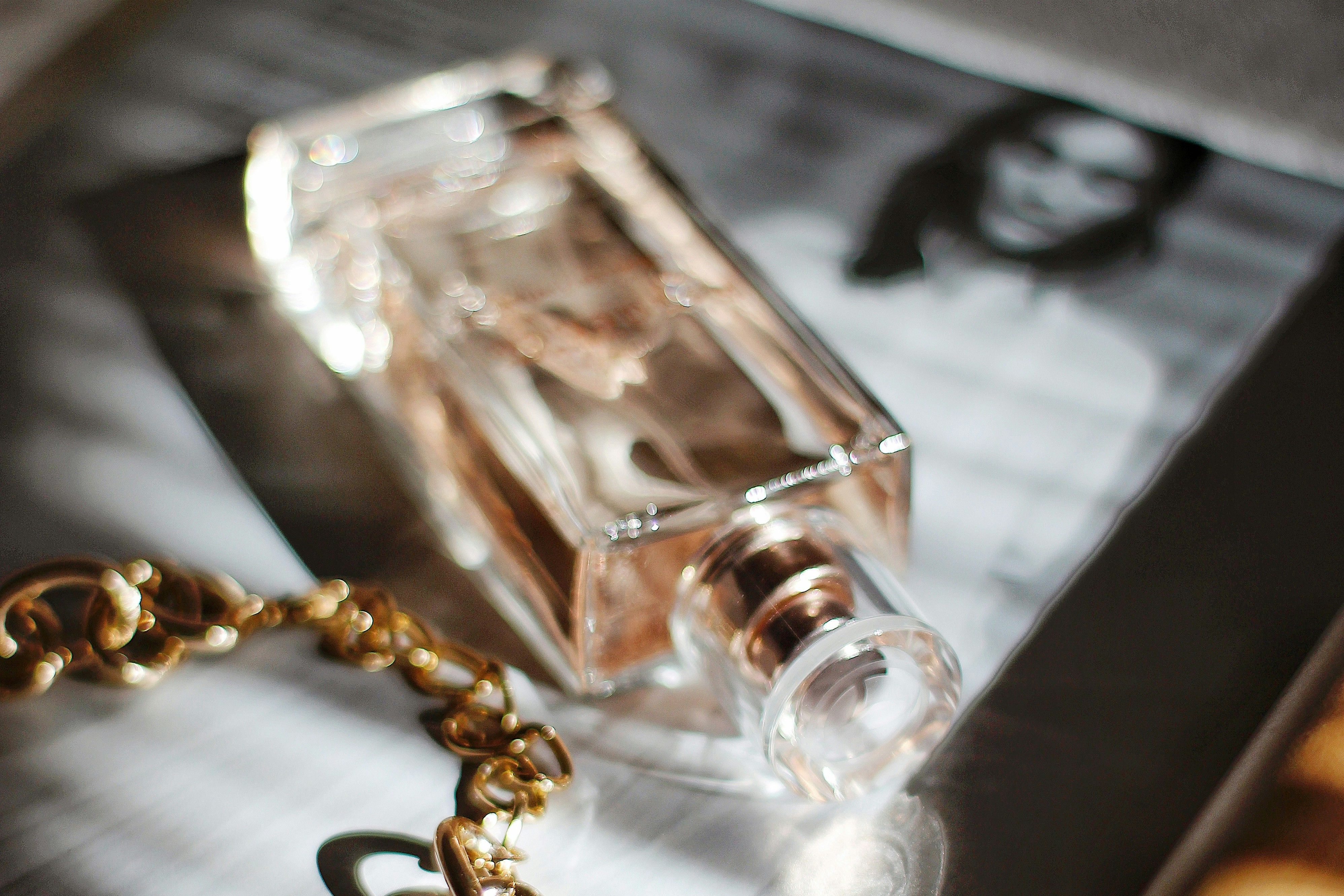 perfume bottle, gold chain, and b&w portrait of person