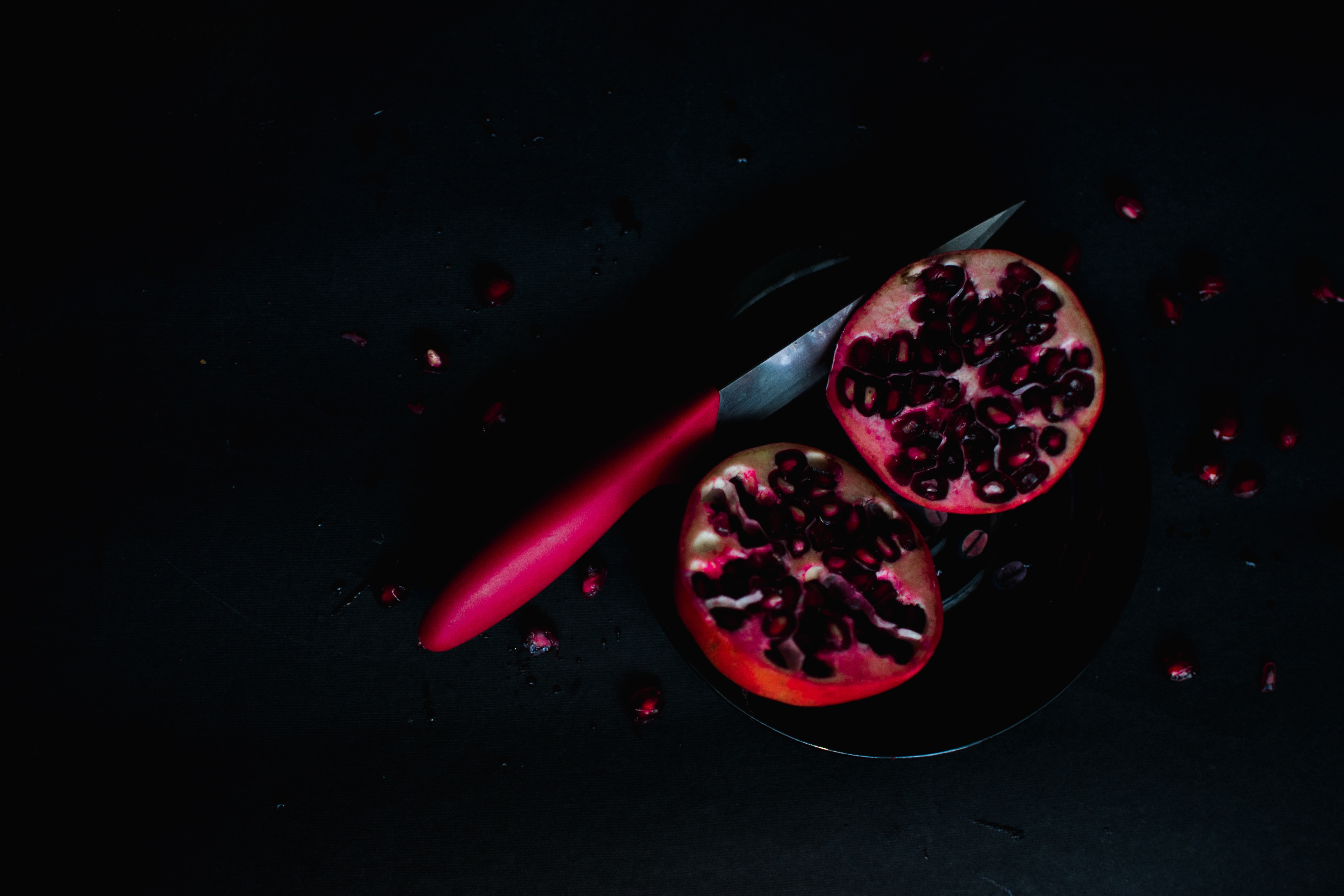 pomegranate cut in half on black background