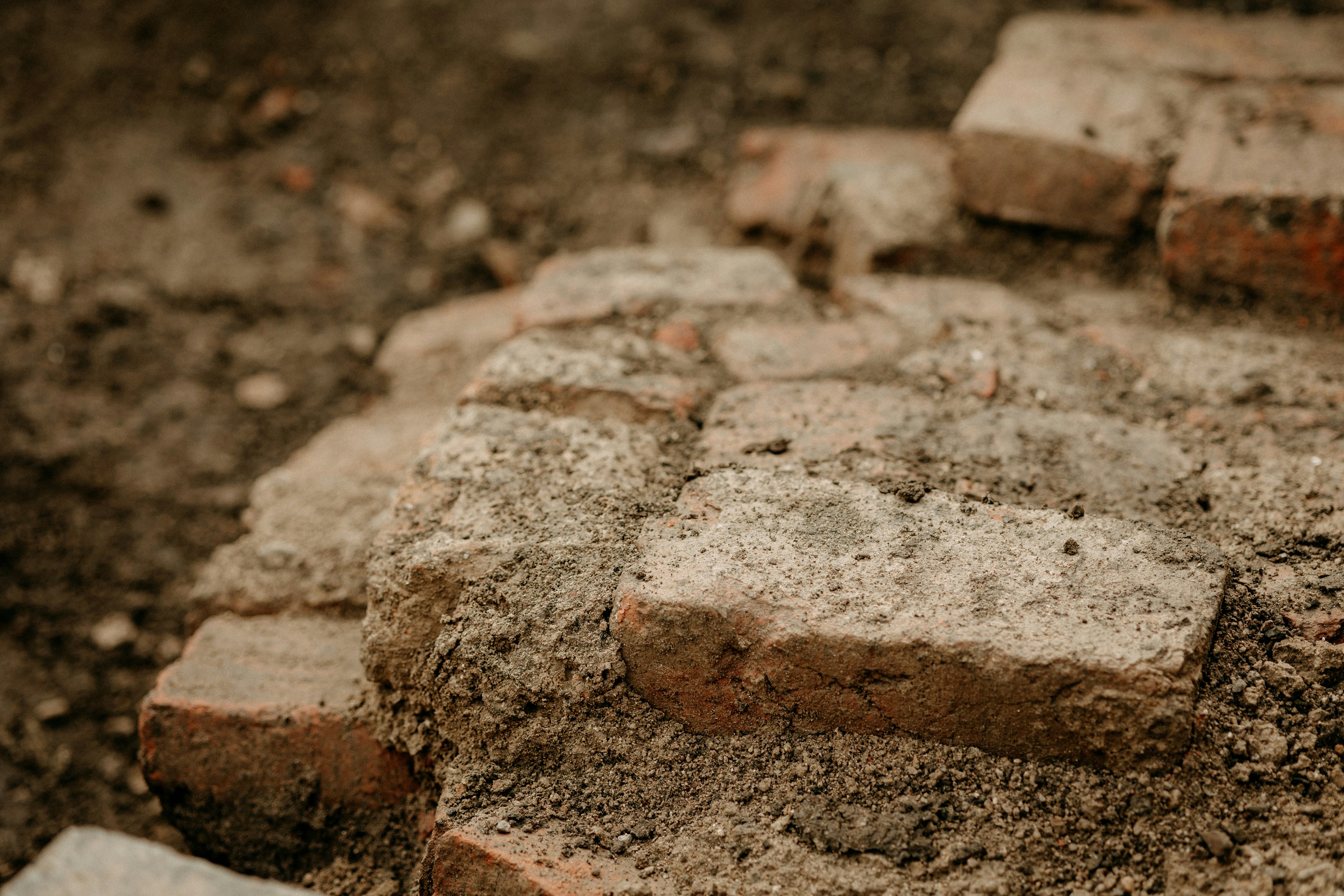 broken brick edge along a dirt-covered street