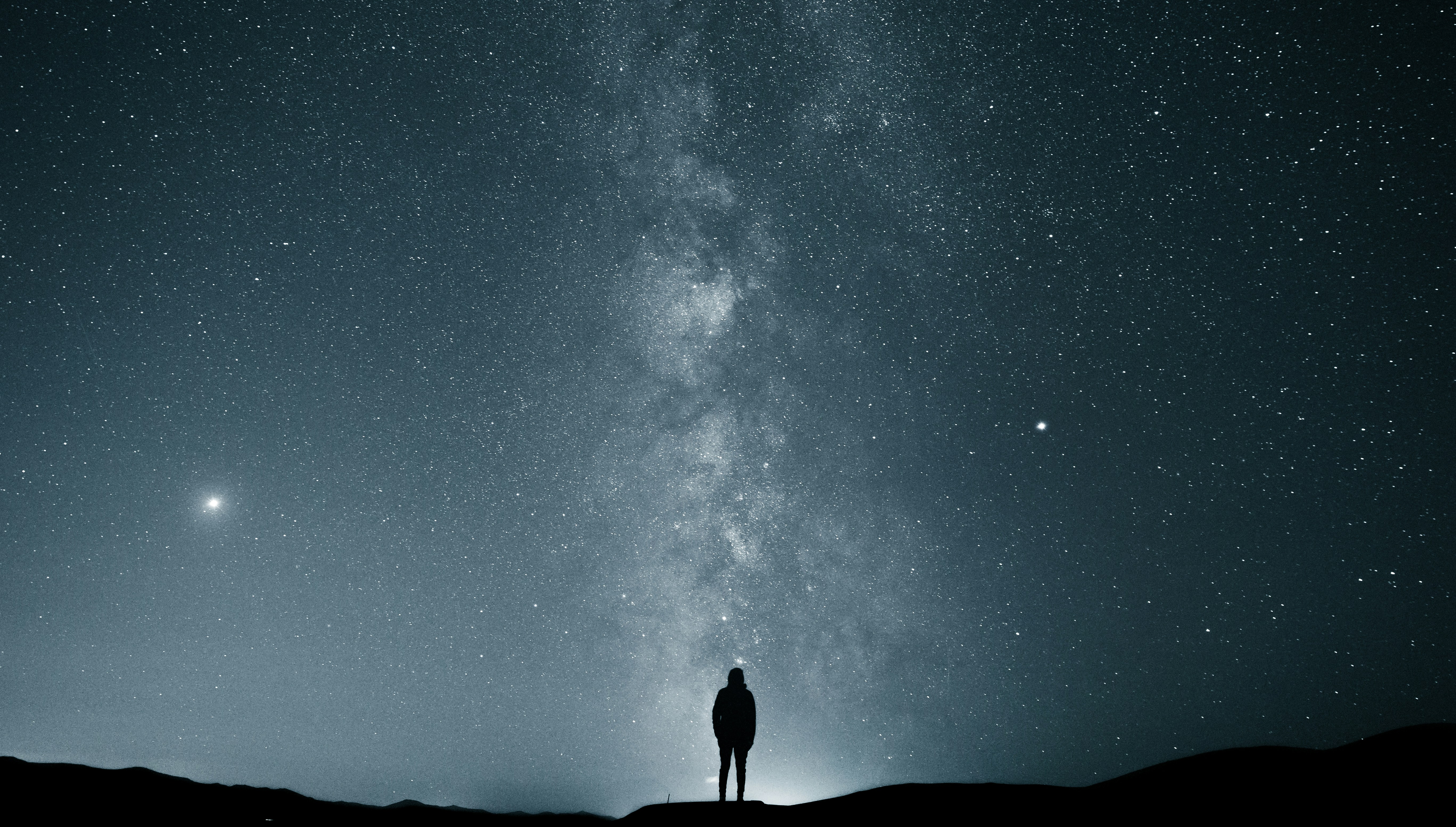 lone person looking up at starry night sky