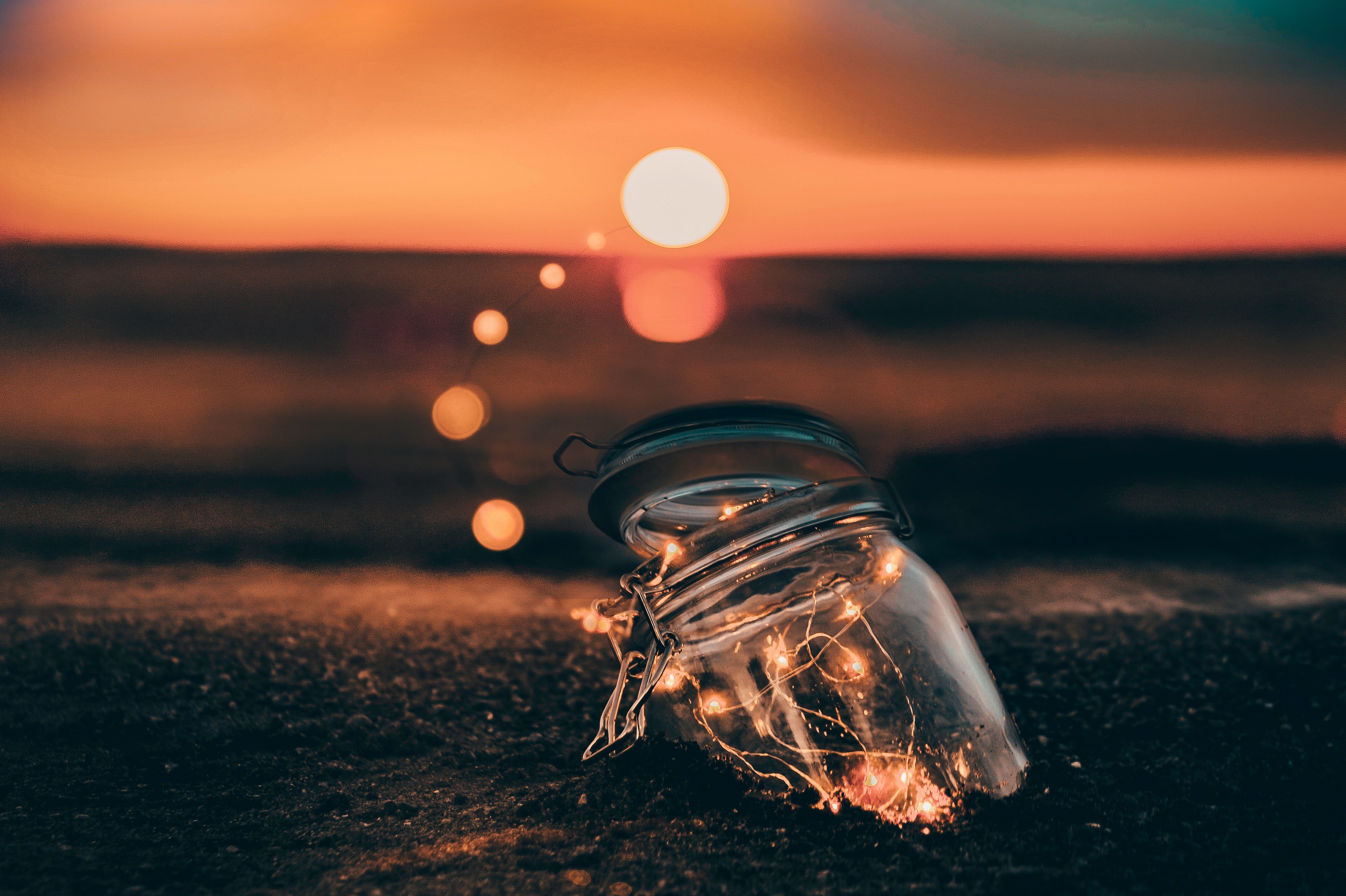 fairy lights in jar on seashore