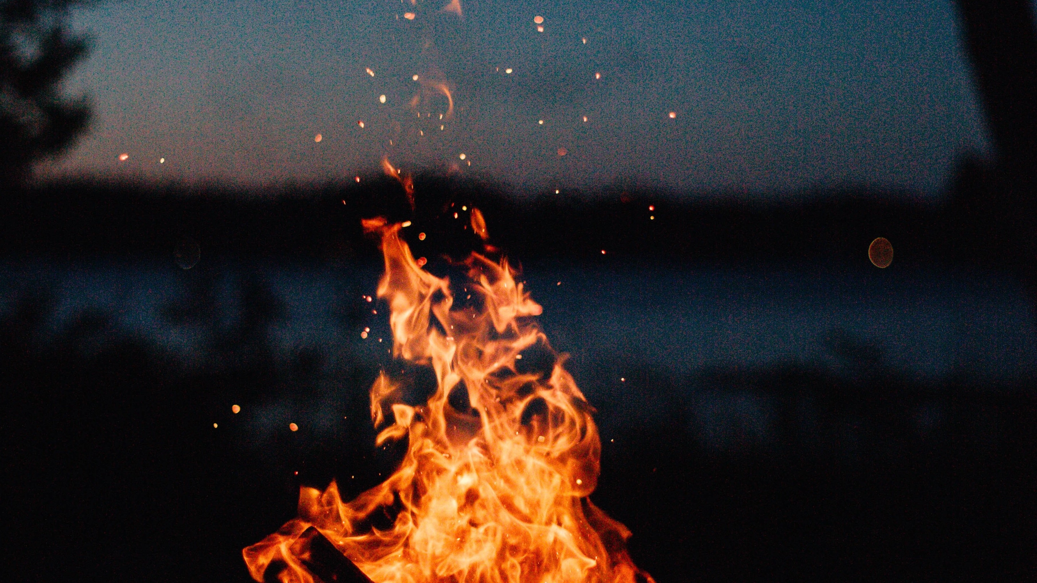 fire sparks against dark water/sky background