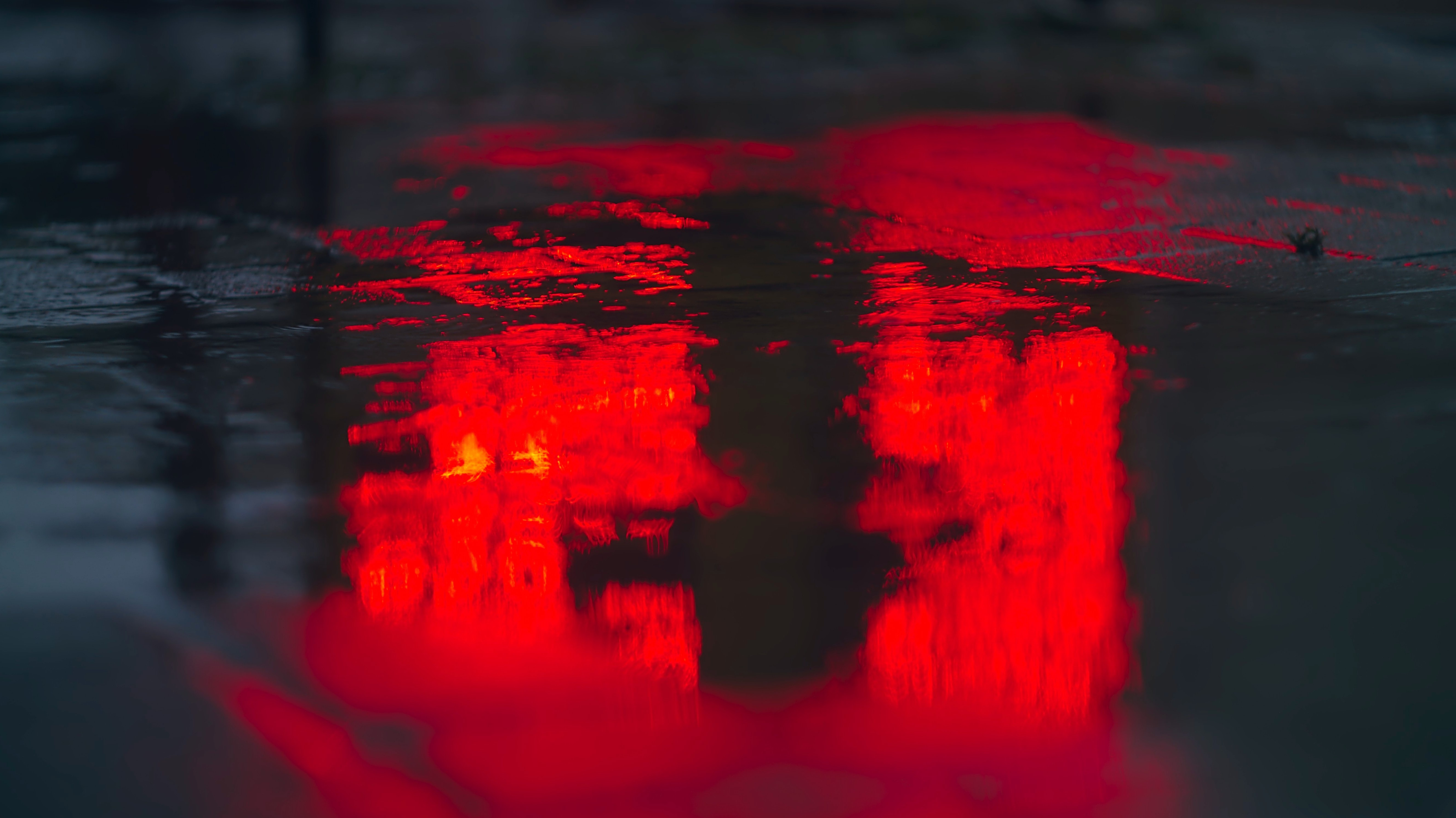 red street lights on a dark wet street