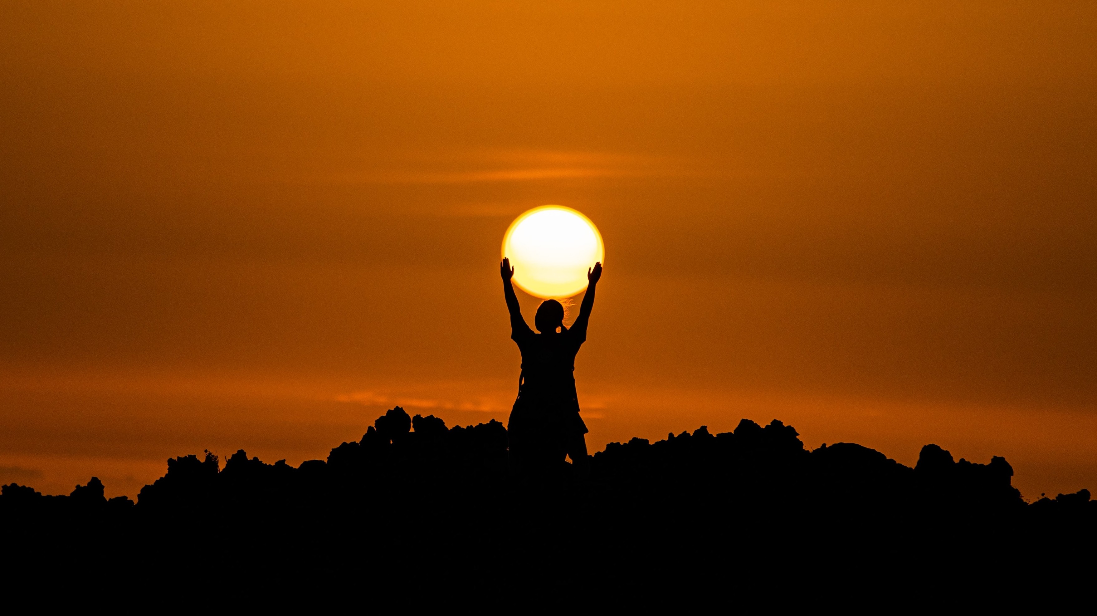 man reaching for sunset