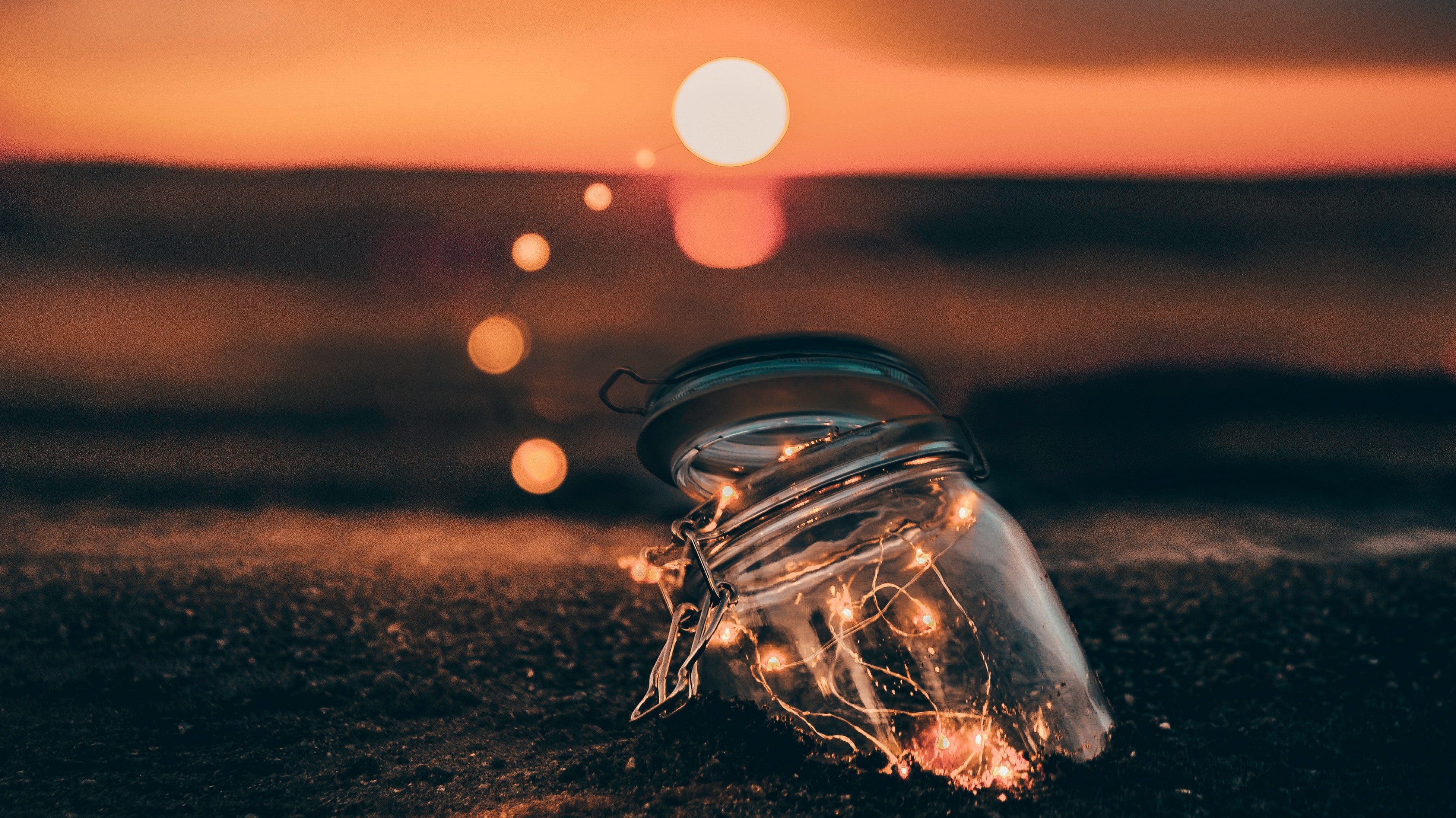 fairy lights in jar on seashore