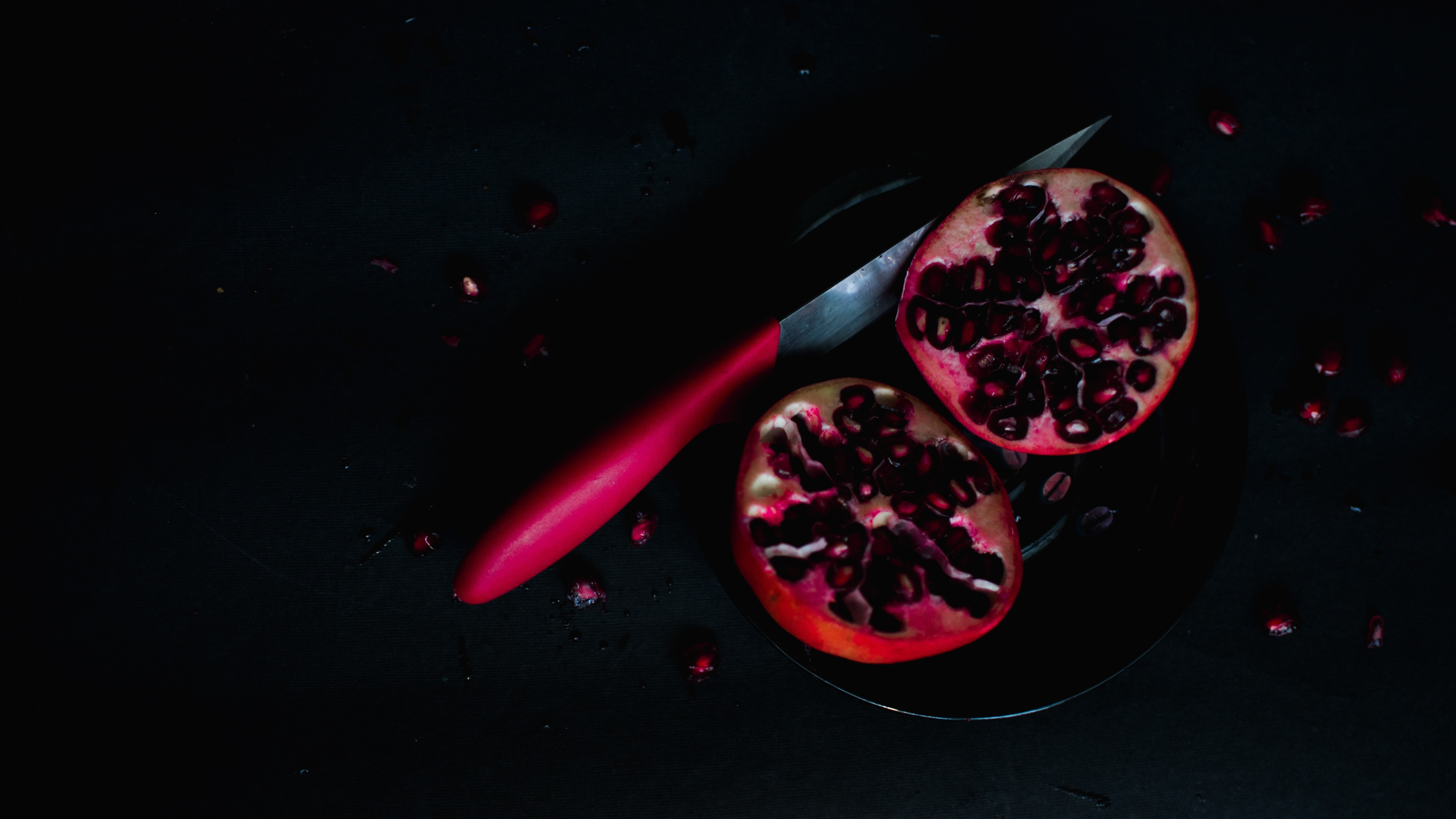 pomegranate cut in half on black background