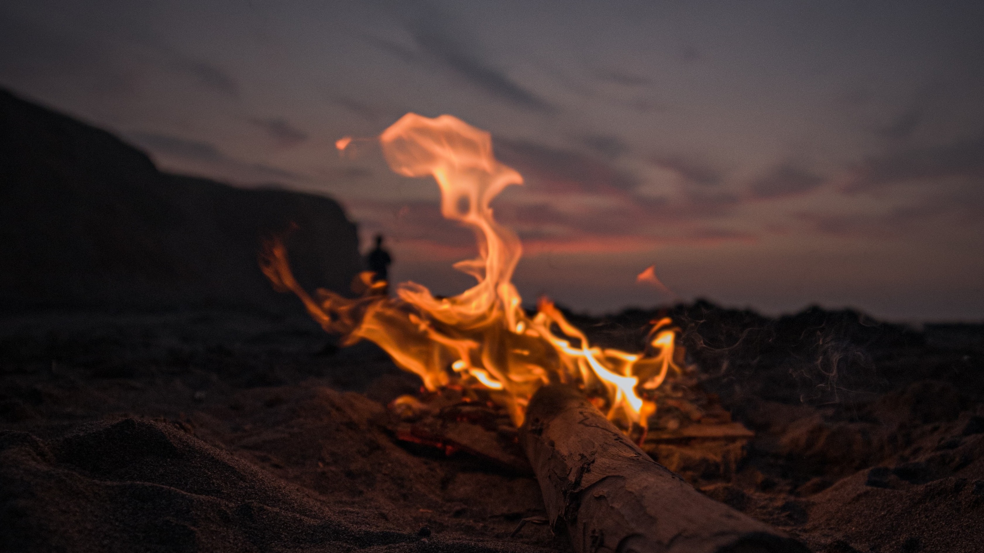 log on fire by edge of water and sky