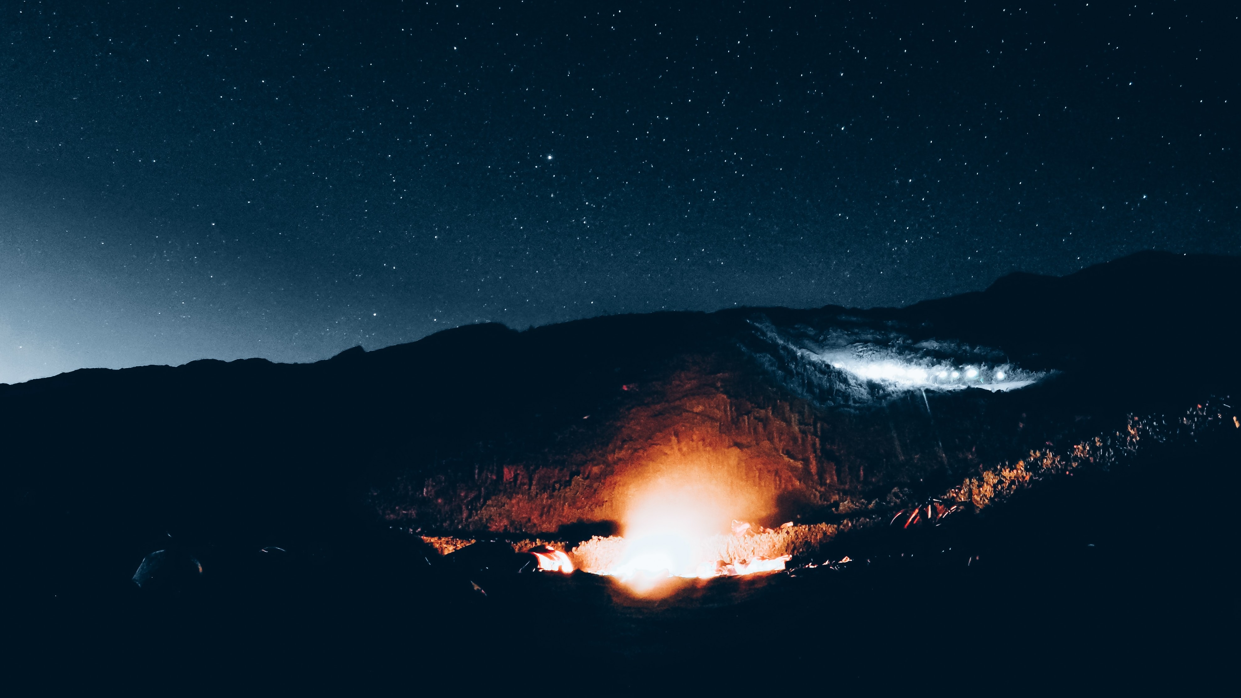 a fire burning beneath a night sky