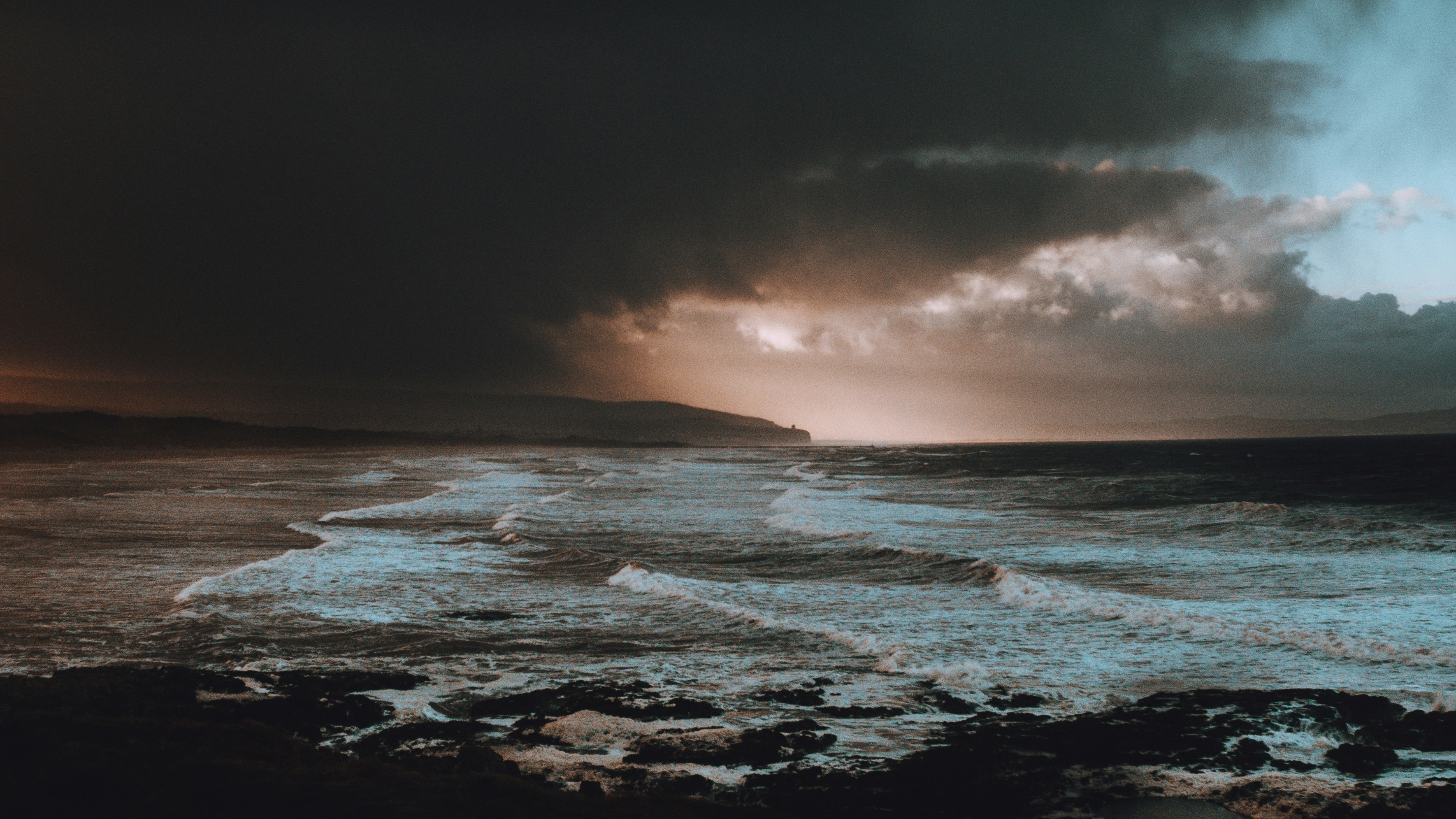 dark seascape with dawn in background