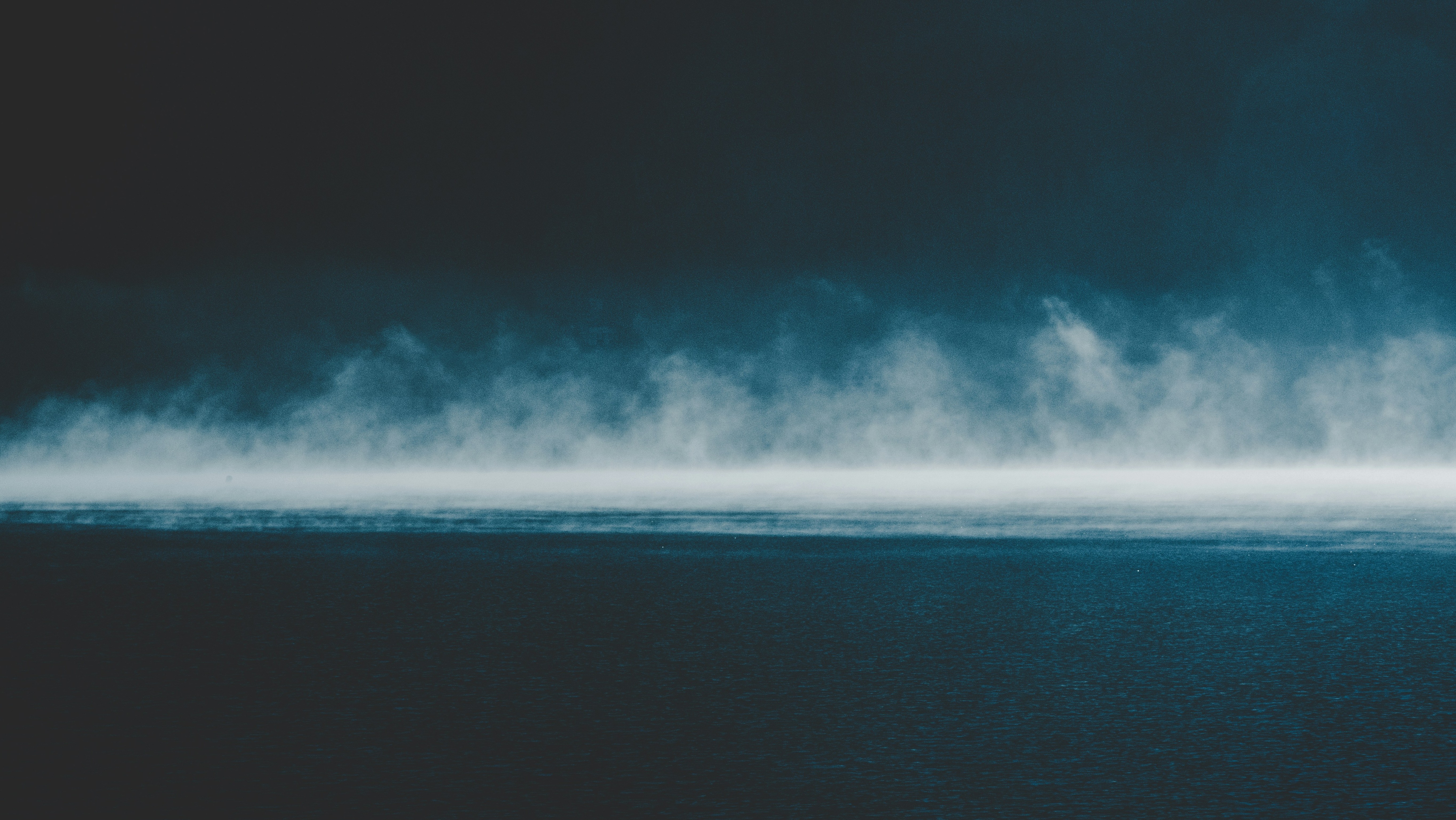 white fog rising above ocean