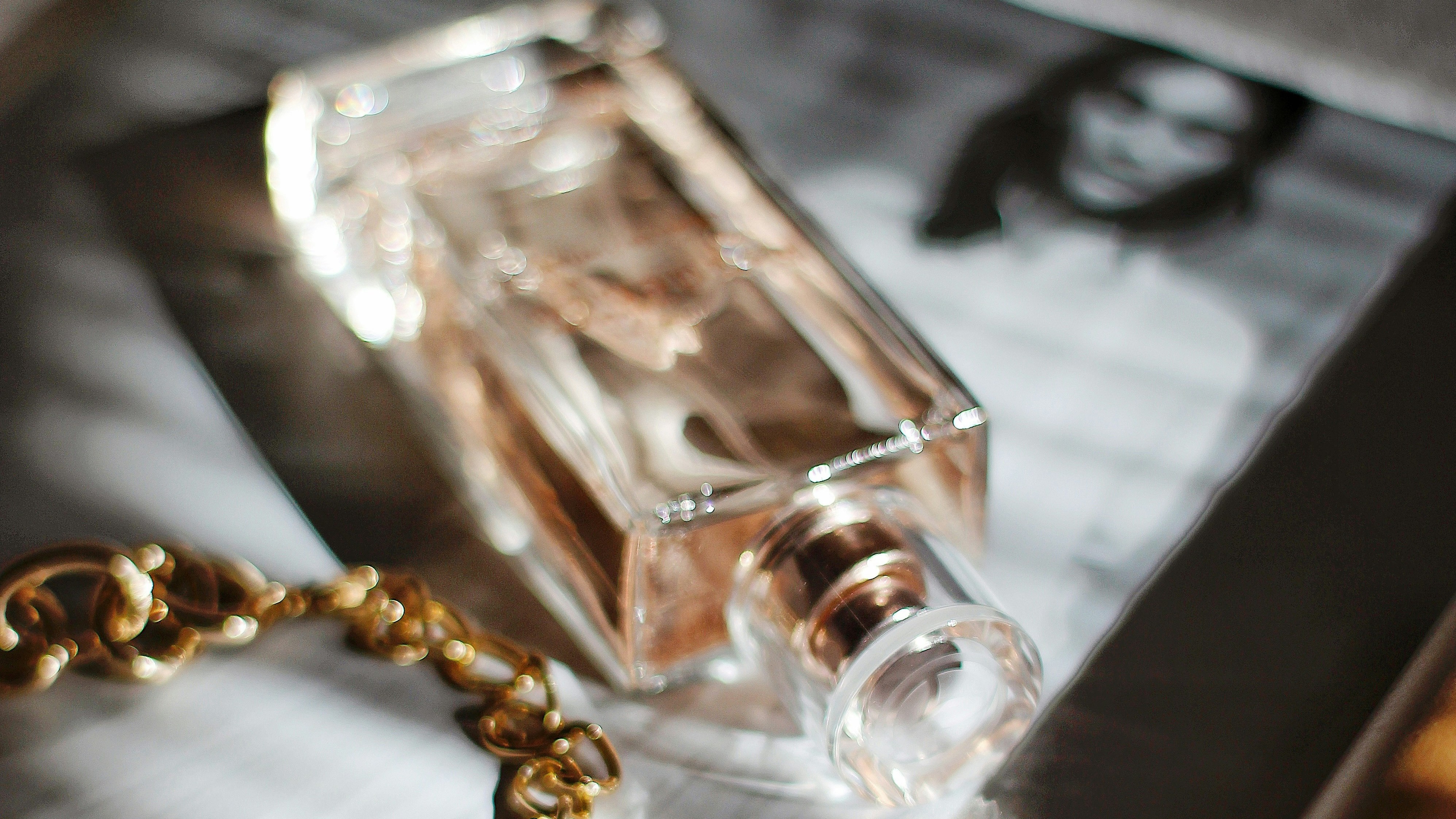 perfume bottle, gold chain, and b&w portrait of person
