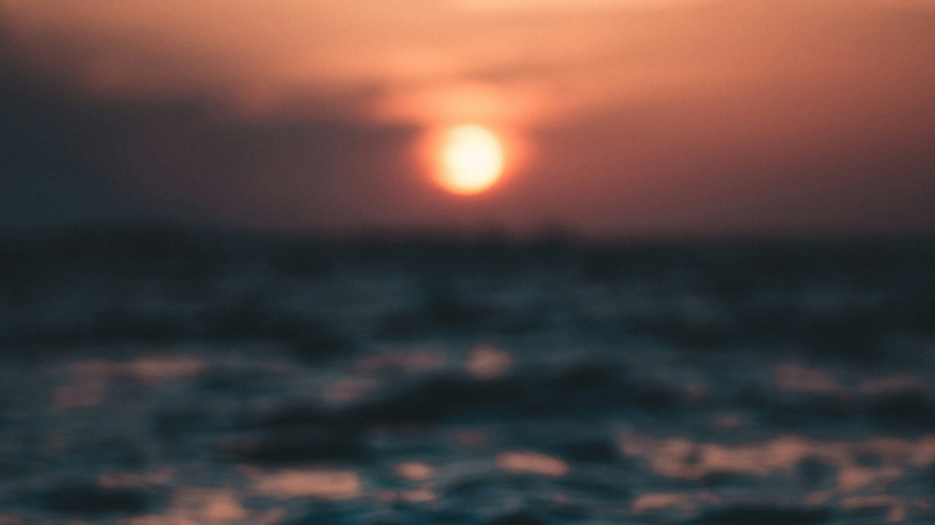 dark orange/red sunset over ocean water