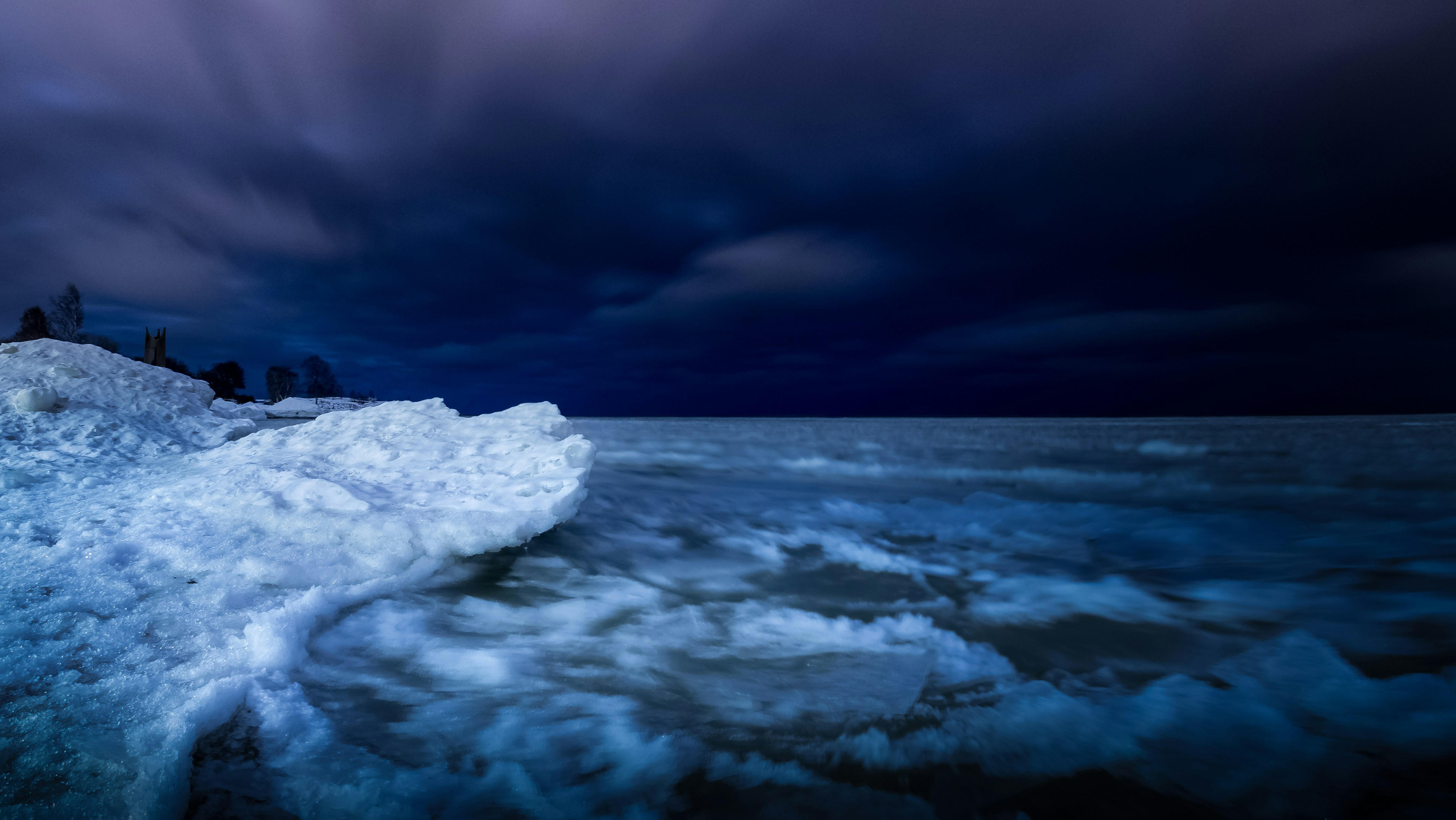 dark purple/blue waters broiling ashore at night