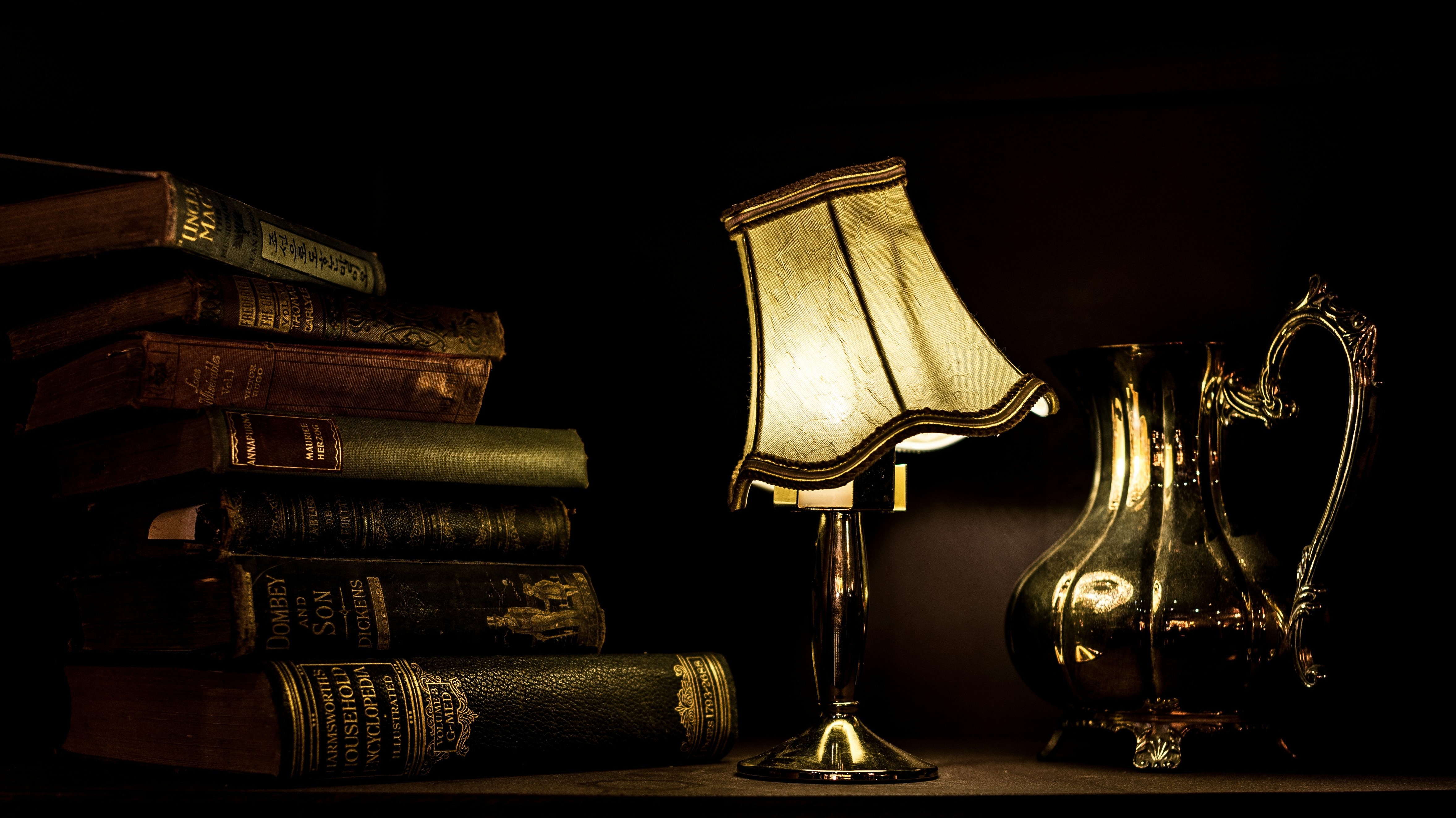 dark books with vintage lamp and metal pot