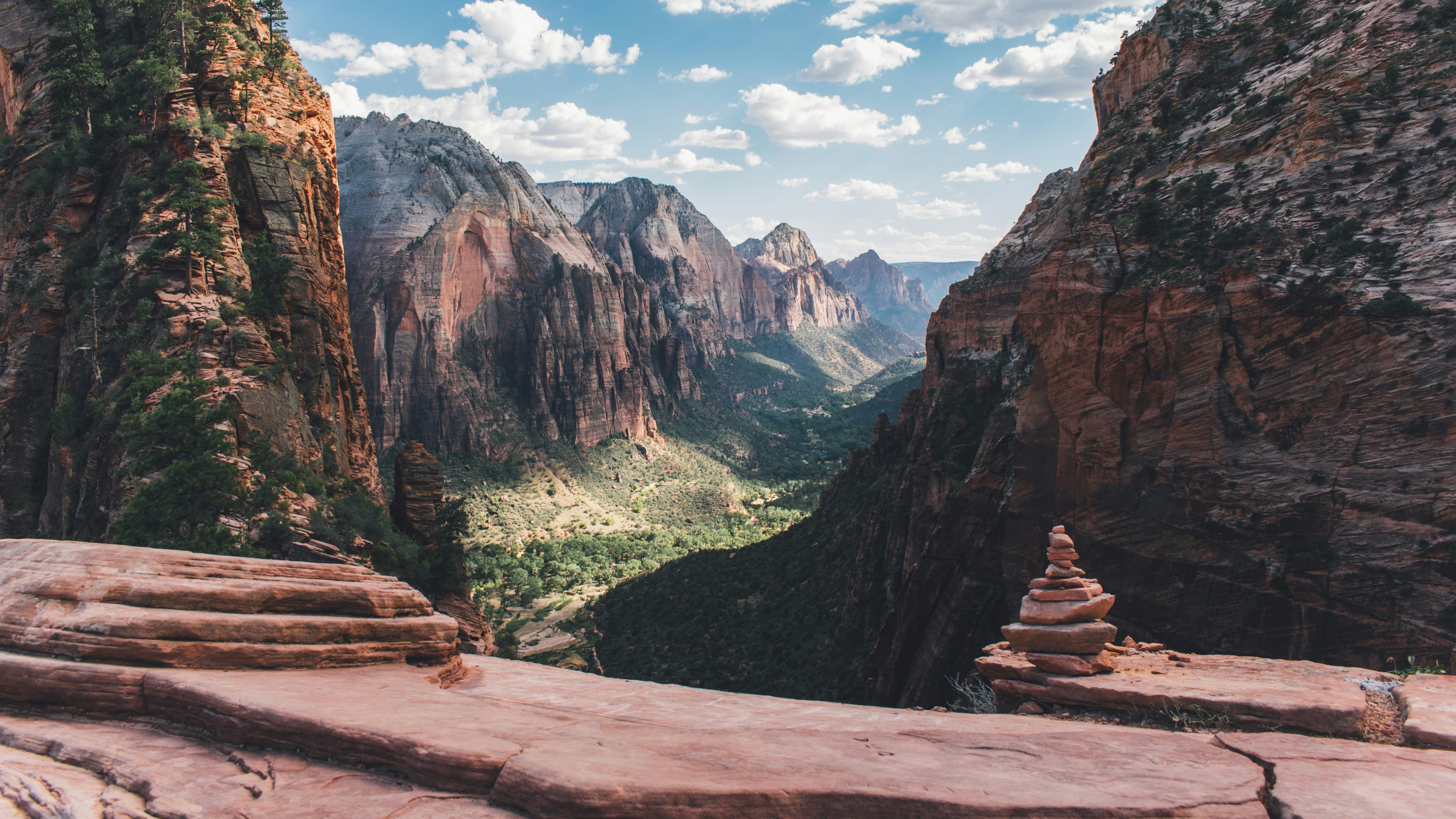 pile of stones on a trail in front of sweeping mountains