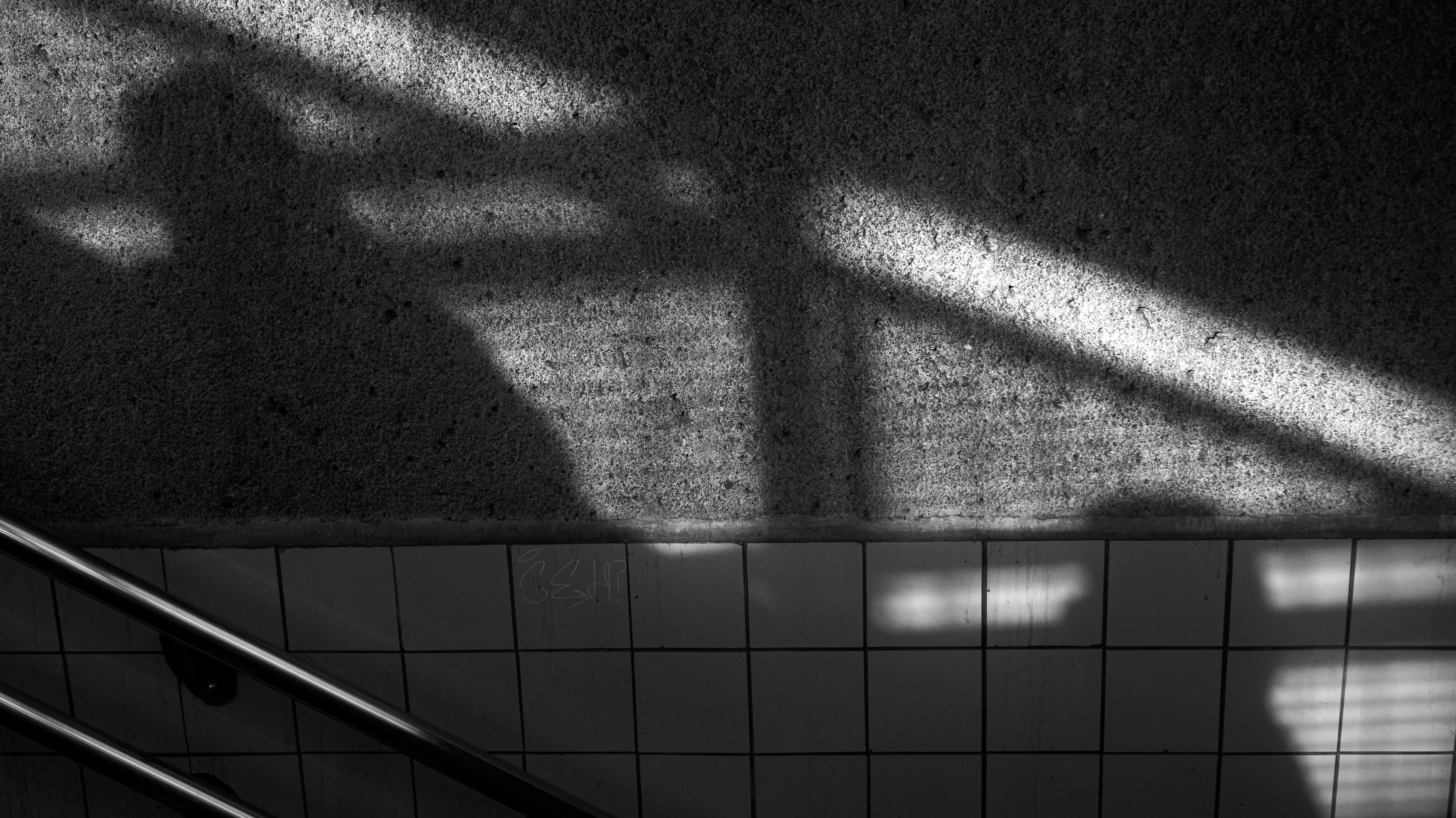 peoples shadows against wall in b&w